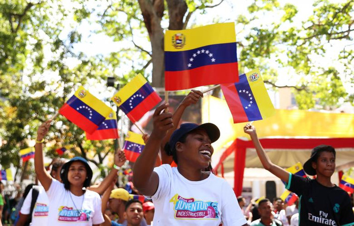 Những người ủng hộ Tổng thống Maduro vẫy cờ khi tham gia cuộc tuần hành ở Caracas.