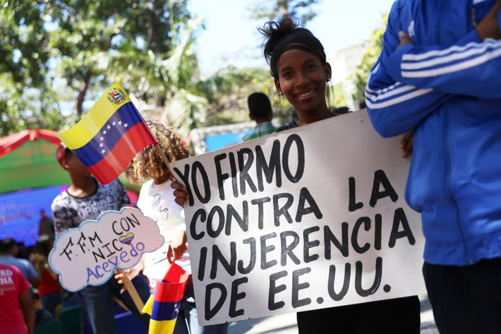 Một người ủng hộ Tổng thống Maduro mang theo biểu ngữ tham gia cuộc tuần hành ở Caracas.