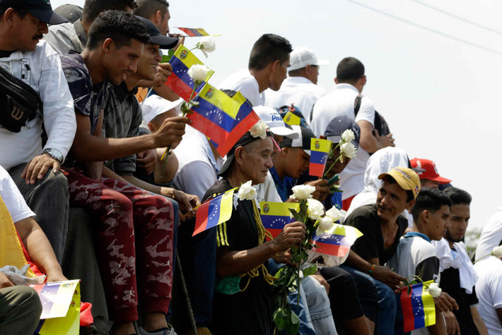 Người dân Venezuela mang theo cờ và hoa hồng trắng ngồi trên chiếc xe “hộ tống” xe chở hàng viện trợ nhân đạo của Mỹ tới Venezuela ở Cucuta, Colombia, cuối tuần trước.