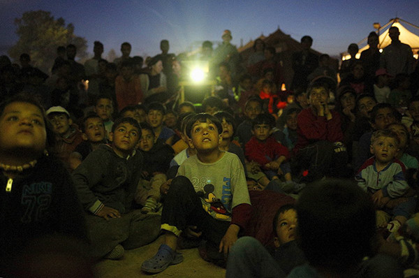 Rất đông trẻ em trong khu trại tị nạn gần làng Idomeni chăm chú xem bộ phim hoạt hình được chiếu trong khu trại.