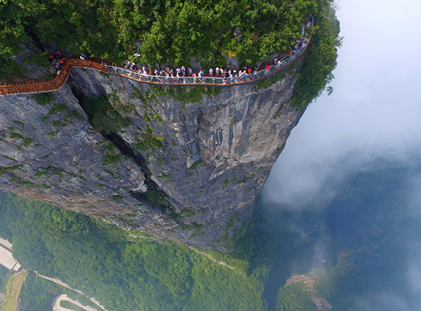 Du khách đi bộ qua lối đi bằng kính có tên Coiling Dragon Cliff được xây dựng trên núi cao ở Công viên quốc gia Thiên Môn Sơn, thành phố Trương Gia Giới, Trung Quốc.