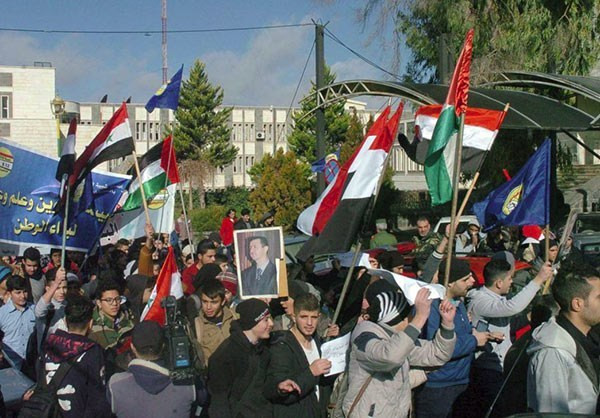 Người dân mang theo bức hình của Tổng thống Syria Bashar al-Assad tuần hành trên đường phố Sweida.