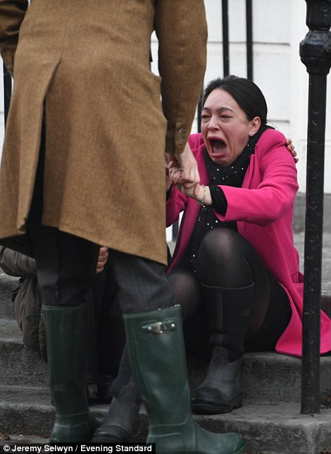 Người phụ nữ hoảng sợ ngồi khóc bên ngoài một ngôi nhà ở Islington. (Nguồn ảnh: Daily Mail).