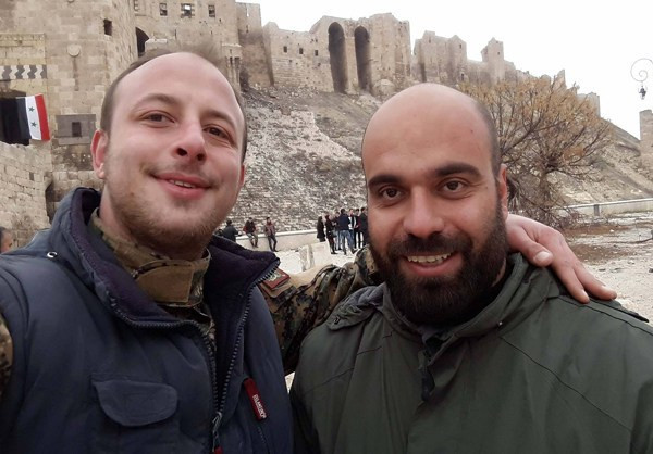 Hai người đàn ông chụp ảnh kỷ niệm, phía sau họ là Thành cổ Aleppo.