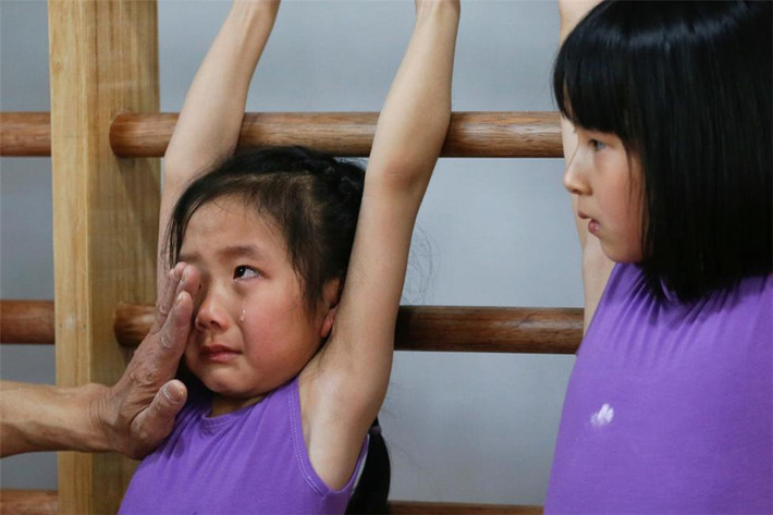 Thầy giáo lau nước mắt và an ủi một bé gái trong giờ học thể dục tại một ngôi trường thể thao ở thành phố Thượng Hải ngày 4/5/2016. (Nguồn ảnh: China Daily)