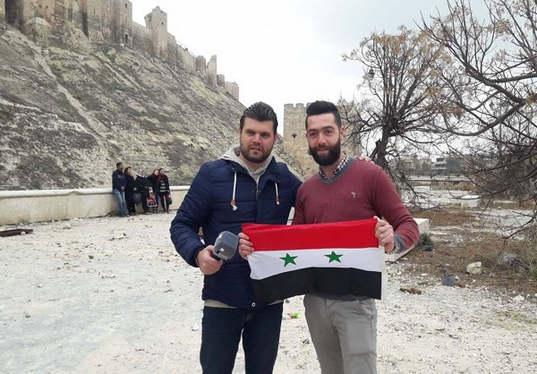 Người đàn ông cầm lá cờ Syria đứng ở khu vực trước Thành cổ Aleppo. (Nguồn ảnh: Fars News Agency)