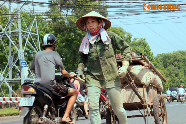 Người phụ nữ gồng vai, kéo chiếc xe cải tiến chở đầy rác thải dưới cái nắng trên 40 độ C.