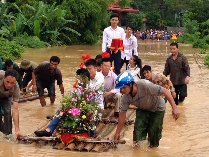 Do nước lũ lớn, một đám cưới phải sử dụng bè mảng để di chuyển qua đoạn đường ở Km 62 QL12B Lạc Sơn - Hòa Bình.
