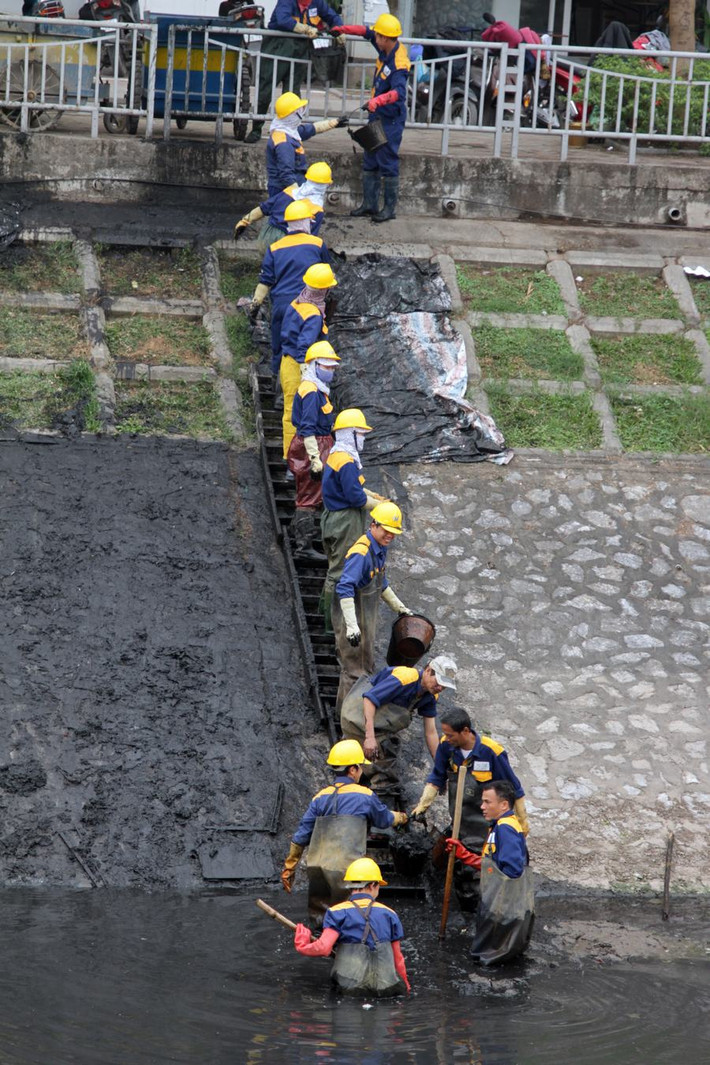 Sông Tô Lịch là một dòng thoát nước thải của Hà Nội, bị ô nhiễm nặng, màu nước đã đen ngòm và bốc mùi khó chịu. Bất chấp cái lạnh, nhiều công nhân đã lội xuống lòng sông để vớt sạch bùn và phế thải.