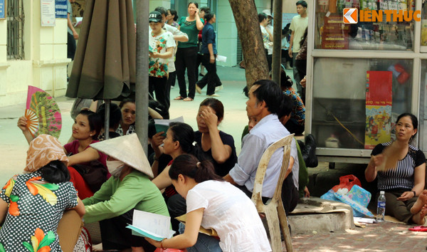 Nhiều người bệnh đến từ các tỉnh như Hà Nam, Nam Định, Thái Bình... đang tụ tập dưới những bóng cây chờ đợi đến lượt khám. "Tôi đợi ở đây từ 7h sáng, đến giờ này là 10h rồi mà vẫn chưa vào khám được, thời tiết oi bức quá nên ra đây ngồi cho mát", bà Nguyễn Thị Hoa, quê Thái Bình (người đội nón) chia sẻ.