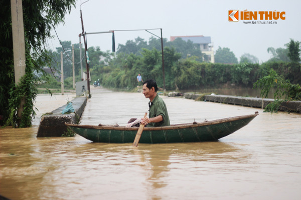 Không đi bộ được qua nước lũ, người dân sử dụng thuyền để di chuyển.