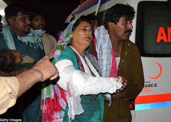 Một người đàn ông Pakistan đỡ người vợ bị thương tại bệnh viện địa phương ở thị trấn Sehwan. Ảnh: Getty Images.