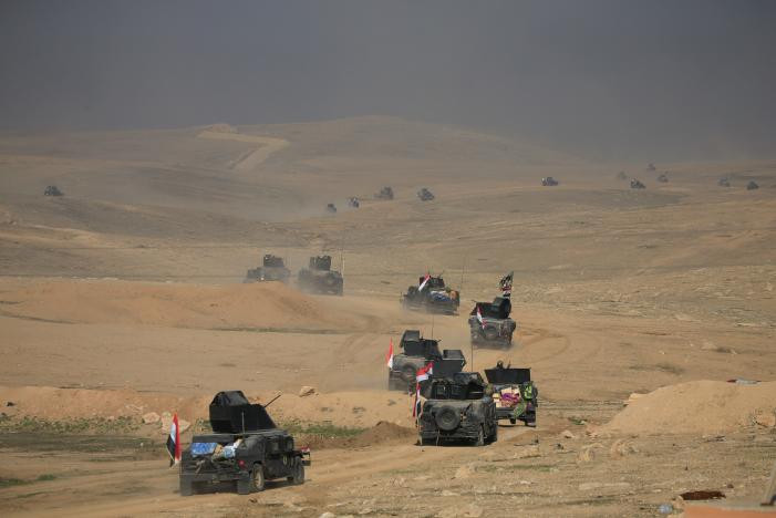Lực lượng chống khủng bố Iraq trên xe quân sự tiến về phía căn cứ quân sự Ghozlani ngày 23/2.(Nguồn ảnh: Reuters)