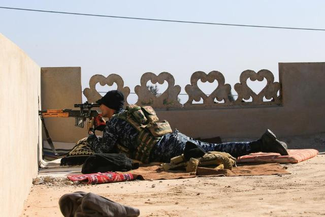 Một tay bắn tỉa của lực lượng Cảnh sát Liên bang Iraq chĩa đầu súng về hướng IS.