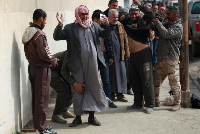 Lực lượng an ninh kiểm tra người dân Mosul nhằm phát hiện các tay súng trà trộn vào.