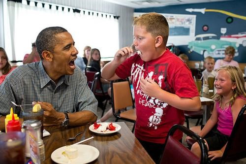 Ông Obama dường như cũng muốn được bé trai đút miếng bánh kem. Ảnh: AP.