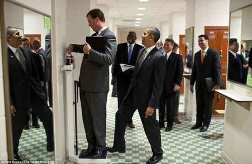 Tổng thống Obama đặt một chân lên chiếc cân mà Giám đốc Nhà Trắng Marvin Nicholson đang đo tại Đại học Texas. Ảnh: White House.