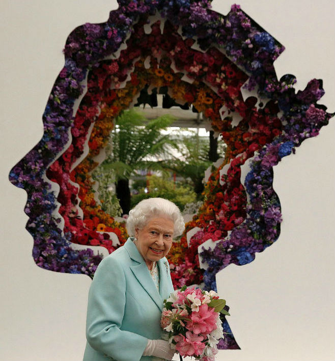 Nữ hoàng Anh Elizabeth II đi qua một khu vườn hoa đầy màu sắc.
