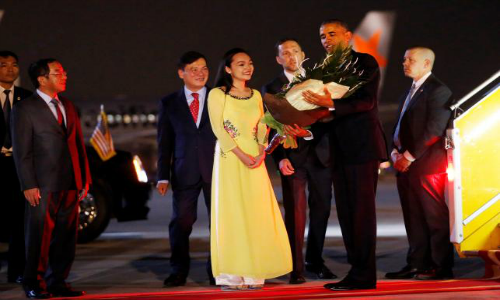 Tổng thống Mỹ Obama nhận hoa từ phái đoàn Việt Nam ngay khi bước xuống chiếc Air Force One. Ảnh Reuters.