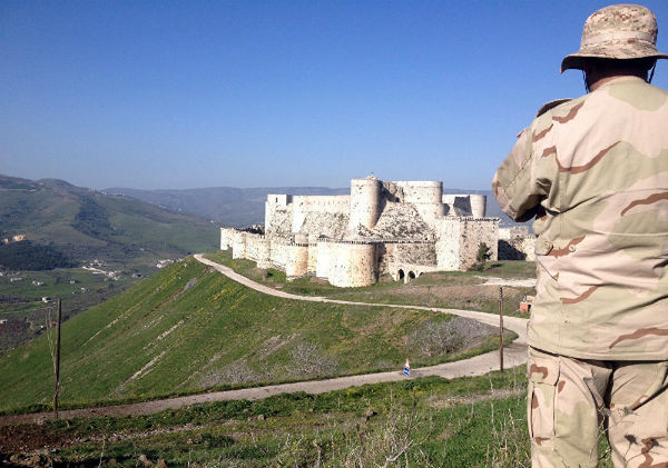 Pháo đài Thập tự chinh thời Trung cổ Crac des Chevaliers ở Syria đã bị hư hại trong cuộc nội chiến suốt 5 năm qua tại tỉnh Homs. Pháo đài được xây dựng từ thế kỷ 11 này sẽ được khôi phục cùng các di tích lịch sử khác. Ảnh: Một binh sĩ Syria nhìn về phía pháo đài Crac des Chevaliers gần biên giới Syria-Lebanon.