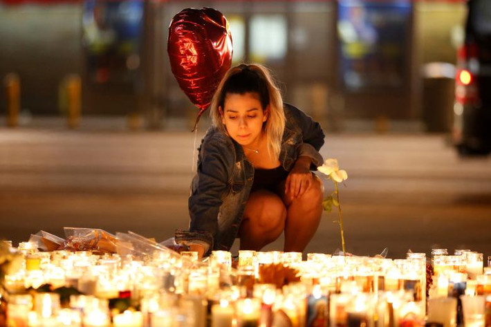 Cô gái thắp nến tưởng niệm các nạn nhân thiệt mạng trong vụ xả súng ở Las Vegas. Ảnh: Reuters.