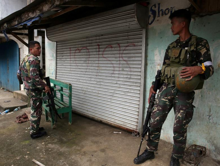 Hai người lính Philippines tuần tra thành phố Marawi sau giải phóng. Ảnh: Reuters.