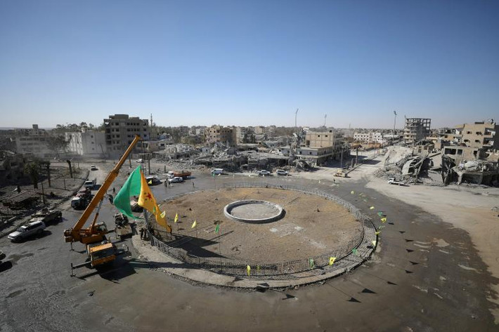 Cờ của lực lượng SDF tung bay tại khu vực vòng xuyến Naim sau khi thành phố Raqqa được giải phóng. Ảnh: Reuters.