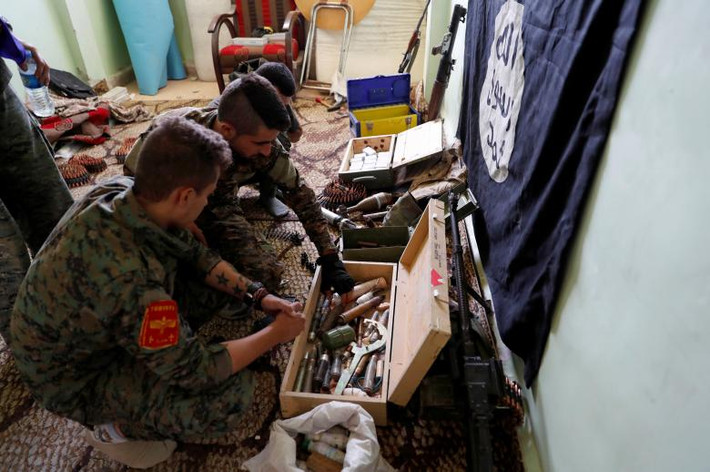 Lực lượng Dân chủ Syria (SDF) kiểm tra số vũ khí và đạn dược được phát hiện trong căn cứ cũ của IS tại Raqqa ngày 7/10. Ảnh: Reuters.