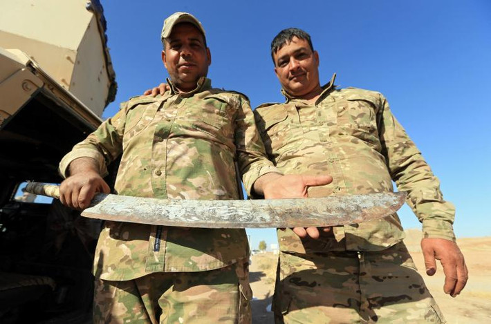 Binh sĩ Iraq cầm một thanh gươm mà các khủng bố IS đã vứt bỏ ở Zumar, tỉnh Nineveh, Iraq, ngày 18/10. Ảnh: Reuters.