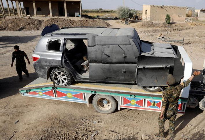 Các chiến binh SDF vận chuyển một chiếc xe bom từng được phiến quân IS sử dụng ở Raqqa ngày 1/10. Ảnh: Reuters.