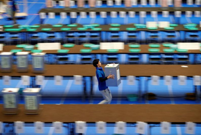 Nhân viên khiêng thùng phiếu chưa mở tại một trung tâm kiểm phiếu ở Tokyo, Nhật Bản. Ảnh: Reuters.