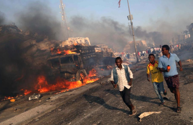 Người dân tháo chạy khỏi hiện trường vụ nổ bom ở quận Hodan, Mogadishu, hôm 14/10. Ảnh: Reuters.