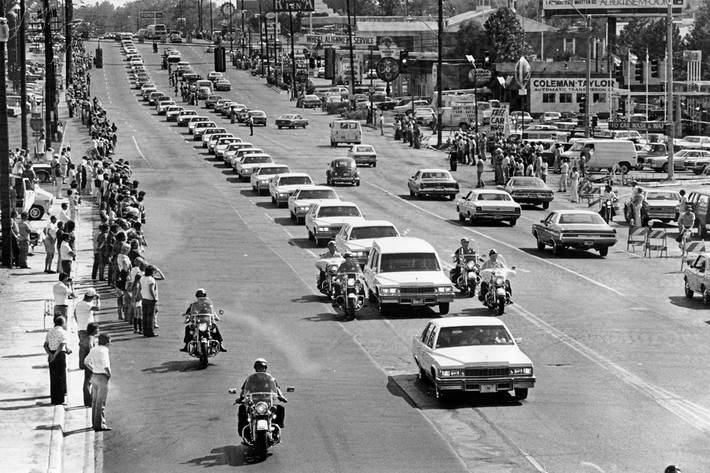 Đoàn ô tô trắng đi dọc đại lộ Elvis Presley đưa thi hài của "Vua nhạc rock and roll" Elvis Presley tới nghĩa trang Forest Hills ở Memphis, bang Tennessee (Mỹ), ngày 19/8/1977. Được biết, vị nhạc sĩ nổi tiếng này qua đời tại nhà riêng ở Memphis ngày 16/8/1977 khi mới 42 tuổi. Ảnh: The Atlantic.