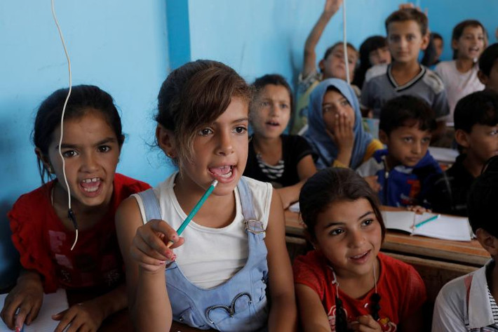 Buổi học đầu tiên của các em nhỏ sau khi đăng ký nhập học tại Hazema, Syria. Ảnh: Reuters.