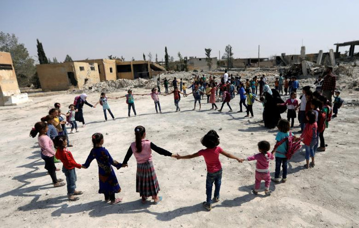 Các em học sinh chơi đùa trên sân trường ở al-Saflaniyeh, Đông Aleppo, Syria, tháng 9/2017. Ảnh: Reuters.