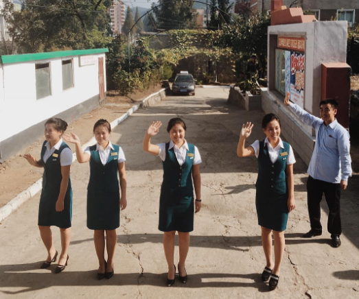 Các nhân viên của khách sạn Jangsusan ở thành phố Pyongsong vẫy chào đoàn du khách. Ảnh: Instagram.