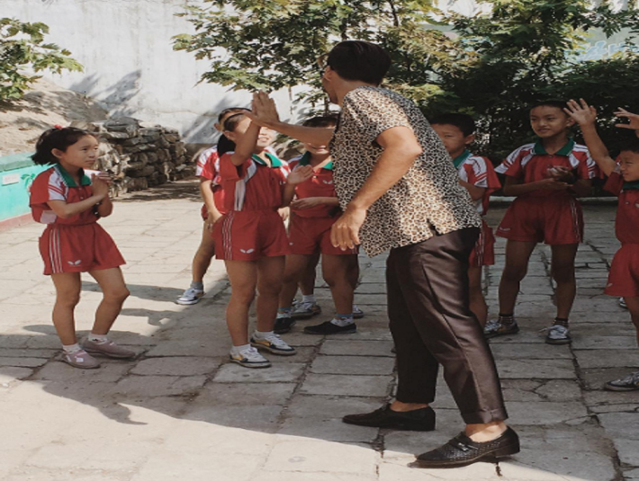 Một du khách "đập tay" với các em học sinh ở Pyongsong sau khi chơi bóng bàn với chúng hồi đầu tháng 9/2017. Ảnh: Instagram.