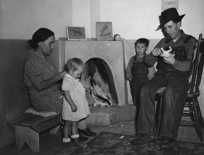 Một gia đình quây quần bên lò sưởi trong nhà ở Trampas, New Mexico, năm 1943. Ảnh: VT.