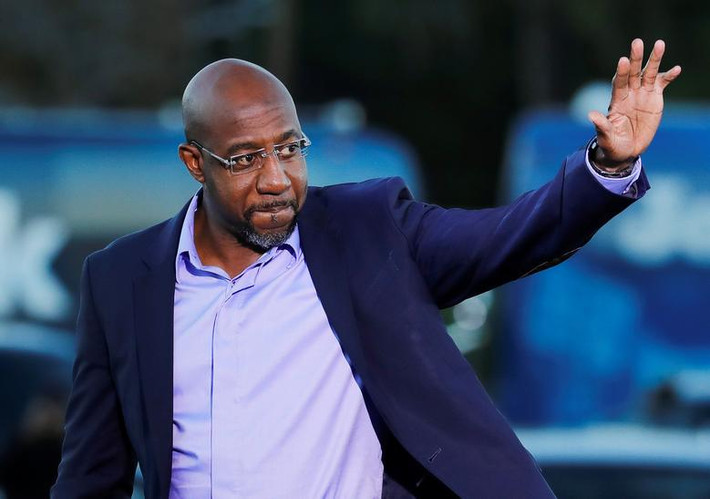 Ứng viên Raphael Warnock vẫy chào người ủng hộ tại Savannah.