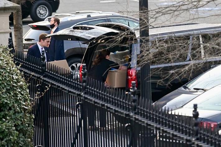 Một nhóm chất thùng carton và vật dụng từ Cánh Tây lên ô tô. Ảnh: Reuters.