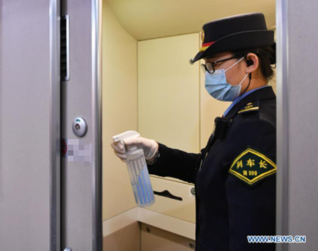 Nữ nhân viên xịt khử trùng trên tàu tại nhà ga ở Phúc Châu, tỉnh phúc Kiến, hôm 28/1. Ảnh: THX.