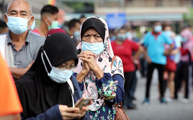 Do ảnh hưởng của dịch bệnh, nhiều người dân Malaysia đang sinh sống tại Singapore xác định sẽ ăn Tết xa quê. Ảnh: Người dân xếp hàng chờ làm xét nghiệm tại Thành phố Klang, Malaysia, ngày 2/12/2020. Ảnh: Reuters.