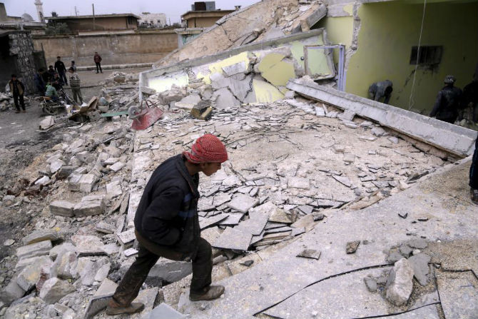 Một bé trai tại ngôi trường đã bị phá hủy ở thị trấn Injara, Aleppo, Syria, ngày 12/1.