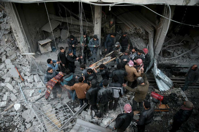 Người dân Syria khiêng một thi thể ra khỏi đống đổ nát ở thị trấn Douma.