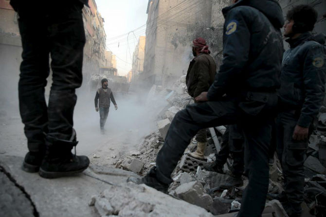 Người dân cố tìm những người còn sống trong đống đổ nát tại thị trấn Douma, Damascus, ngày 10/1.