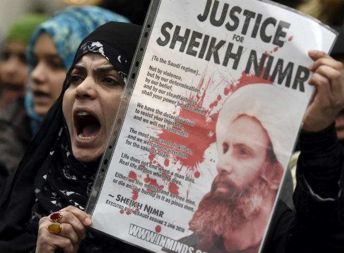 Người biểu tình mang theo ảnh của giáo sĩ Sheikh Nimr al-Nimr tập trung bên ngoài Đại sứ quán Ả-rập Xê-út ở London, Anh, ngày 3/1/2016.