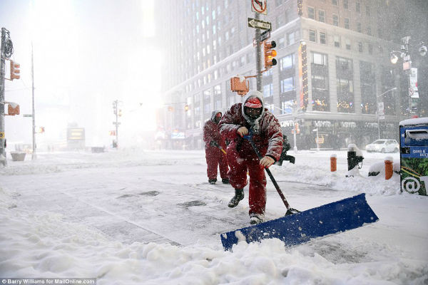 Công nhân vất vả dọn tuyết trên đường phố ở New York.