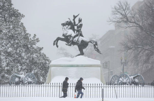 Người dân đi qua tượng Pierre Charles L'Enfant giữa lúc tuyết rơi ở Washington.