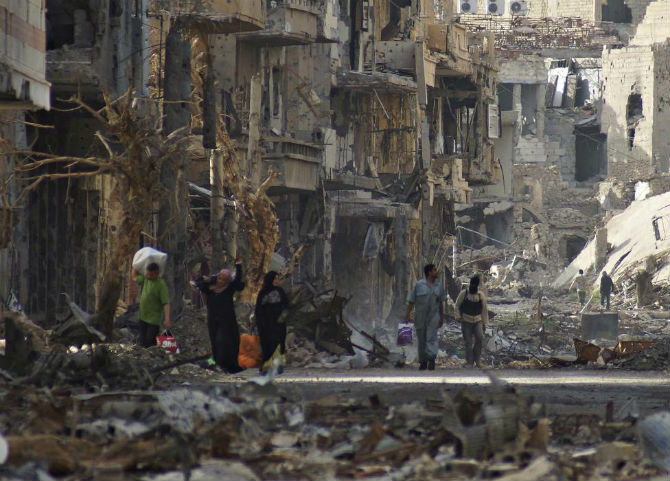 Người dân và một chiến binh Quân đội Syria Tự do đi bộ trên một con đường ở Deir al-Zor, ngày 7/4/2013.