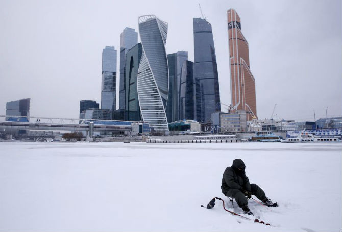 Một người đàn ông đang câu cá ở sông Moskva đóng băng gần “Moskva-City”, thủ đô Moscow, Nga, ngày 13/1.